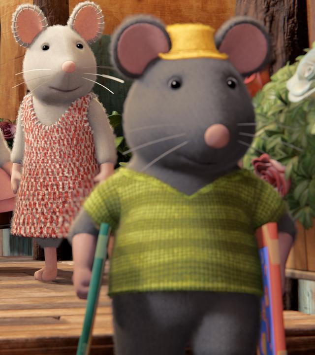 Sam, Ella und Julia stehen draußen auf einem Treppenabsatz und schauen Tonio nach, der mit zwei Bildern unter den Armen die Treppe hinunterläuft.