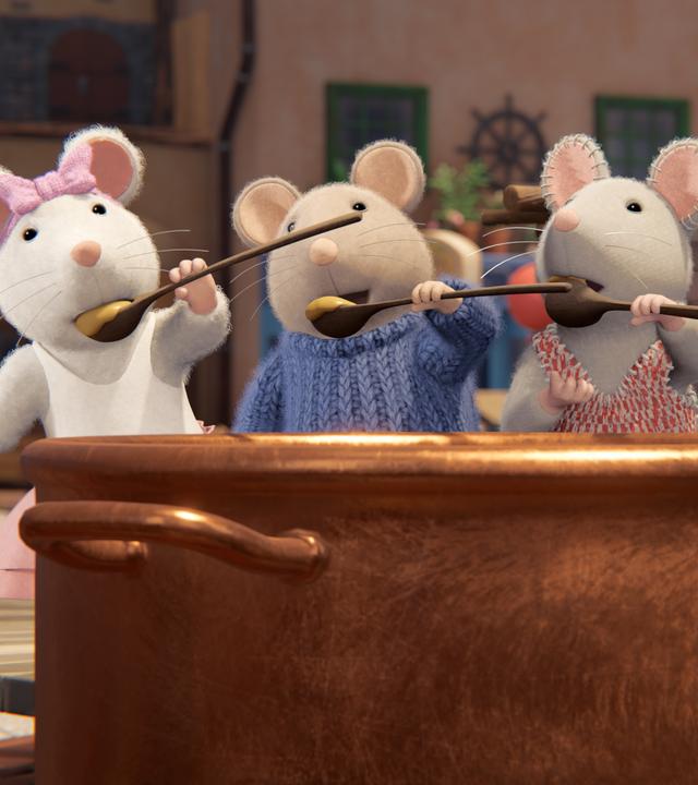 Ella, Sam, Julia und Tonio stehen hinter einem riesigen, braunen Ton-Topf mit flüssigem Käse. Alle haben Käse auf ihren Holzlöffeln und probieren ihn gerade.