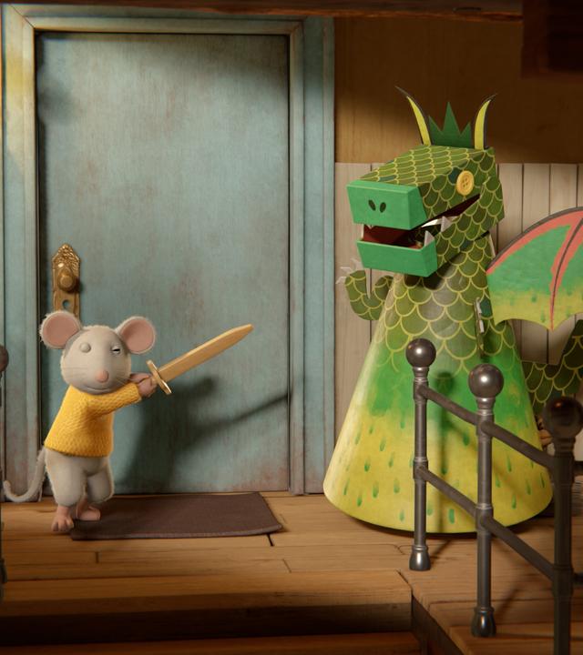 Ben, der kleine Bruder von Sam, richtet mit der Hand ein Holzschwert gegen einen riesigen, grünen Drachen. Der Drachen ist von Sam selbstgebastelt