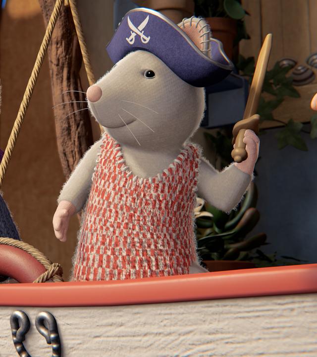 Julia und Sam befinden sich auf dem Boot von Opa Seemann. Julia ist als Piratin verkleidet. Sie trägt einen Piratenhut und hält in ihrer linken Pfote ein Schwert. Sam steht neben ihr, er trägt eine violette Stirnbinde und ruft etwas.