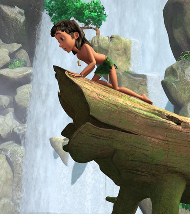 Mogli und Jakala kriechen auf allen Vieren auf einem Baumstamm und blicken von dort in die Tiefe. Im Hintergrund ist ein Wasserfall.