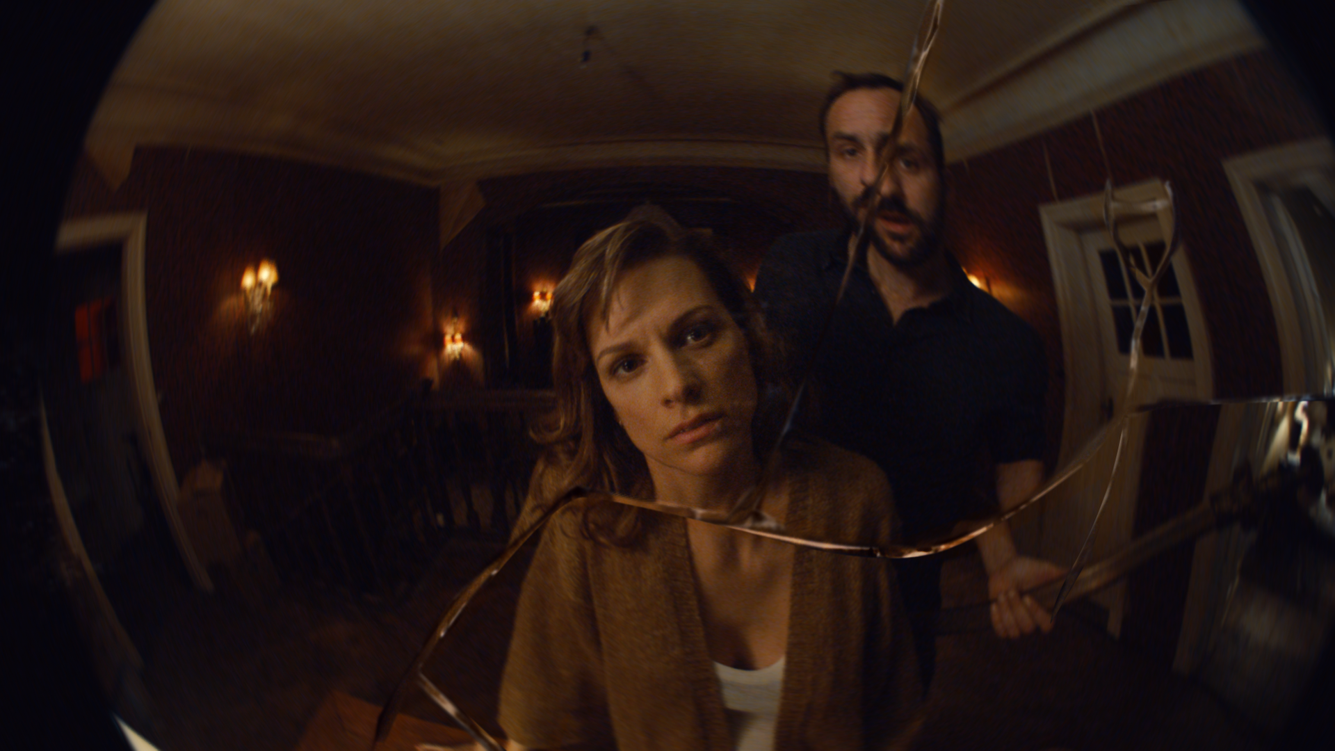 Mie und Benoit schauen in einen zerbrochenen Spiegel