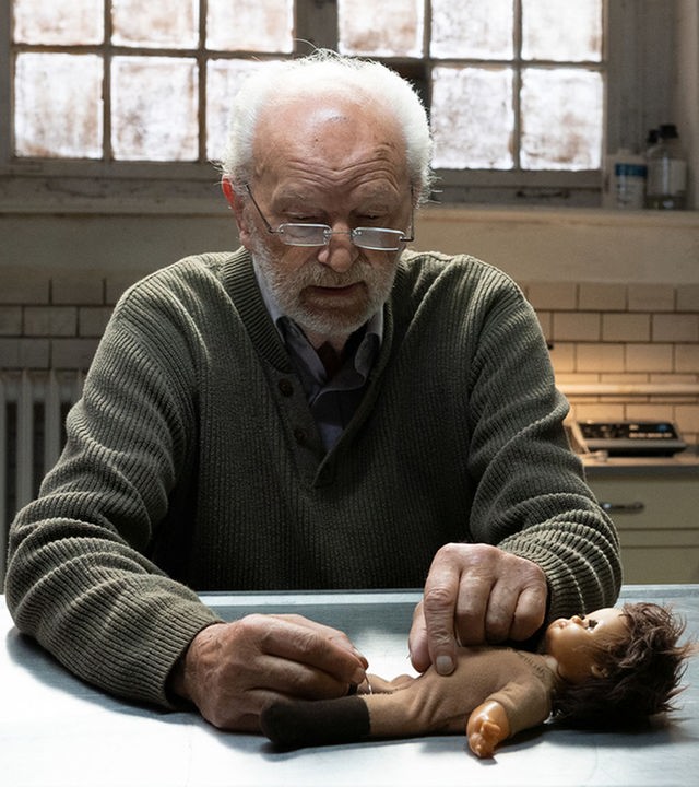 Pathologe Peter simuliert an einer Kinderpuppe eine pathologische Untersuchung. 