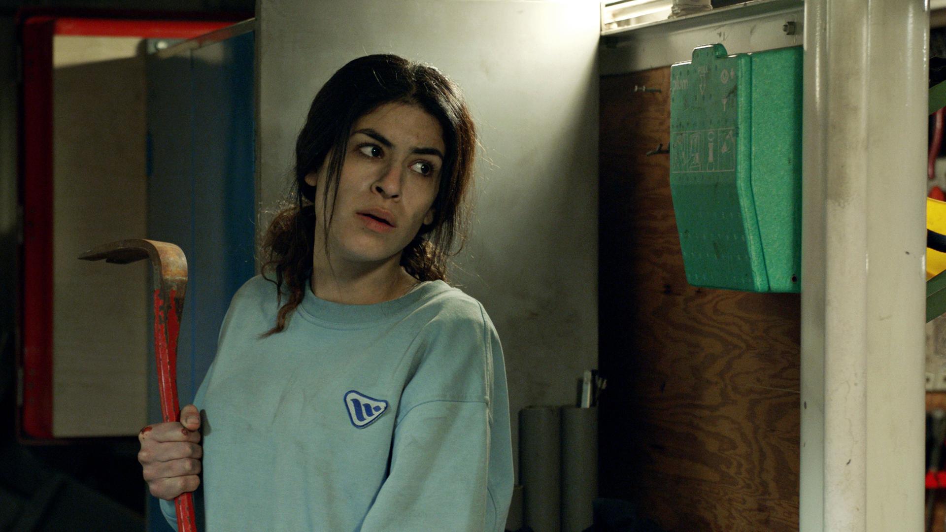 June (Jasmin Mahmoud) nimmt mit einer Brechstange den Kampf gegen die bewaffneten Entführer auf.