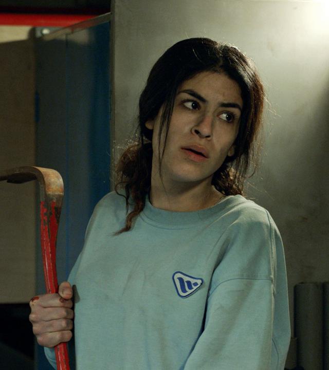 June (Jasmin Mahmoud) nimmt mit einer Brechstange den Kampf gegen die bewaffneten Entführer auf.