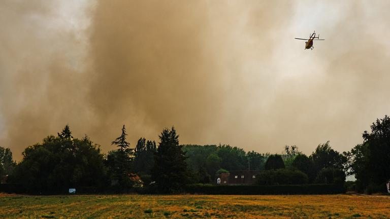 Rauch steigt in den Himmel auf, während Waldbrände durch den historischen Wald von Fontainebleau wüten. Ein Hubschrauber fliegt über den Wald