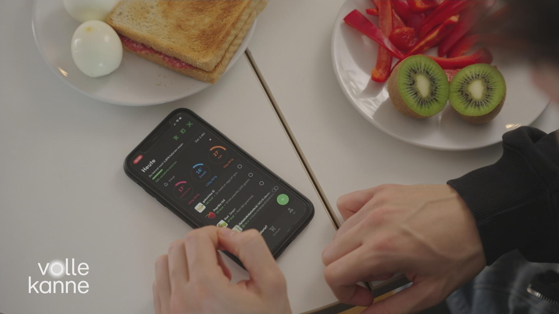 Handy mit geöffnter App liegt auf gedecktem Frühstückstisch