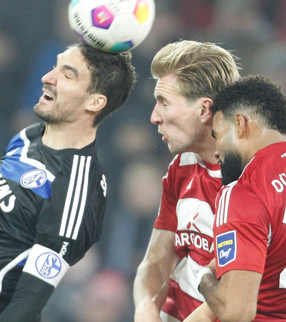 Die Düsseldorfer Vincent Vermeij (M) und Jamil Siebert (r) und der Schalker Marcin Kaminski (l) kämpfen um den Ball. 