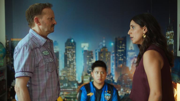 Andi (Milan Peschel) und Mari (Maryam Zaree) stehen sich in Roccos Kinderzimmer vor einer Fototapete mit einer Skyline gegenüber und schauen sich ernst in die Augen. Im Hintergrund sitzt Rocco (Hoang Minh Ha) und blickt zu Mari.
