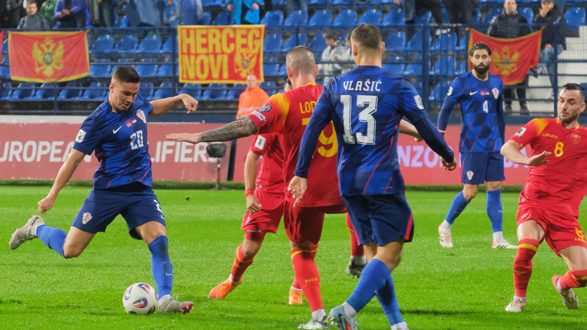 Der Kroate Franjo Ivanović (links) schießt den Ball während des Qualifikationsspiels zwischen Montenegro und Kroatien.
