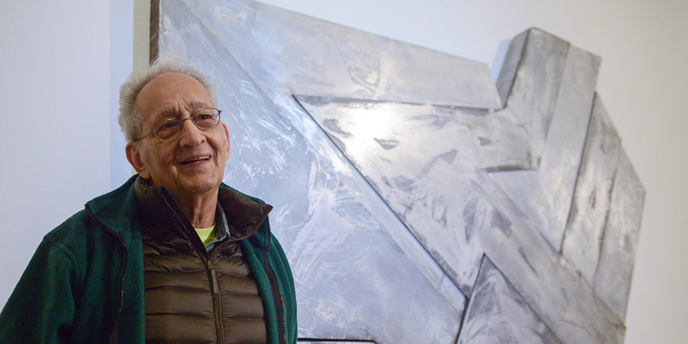 Frank Stella posiert vor einem seiner Werke in einer Ausstellung in Warschau.