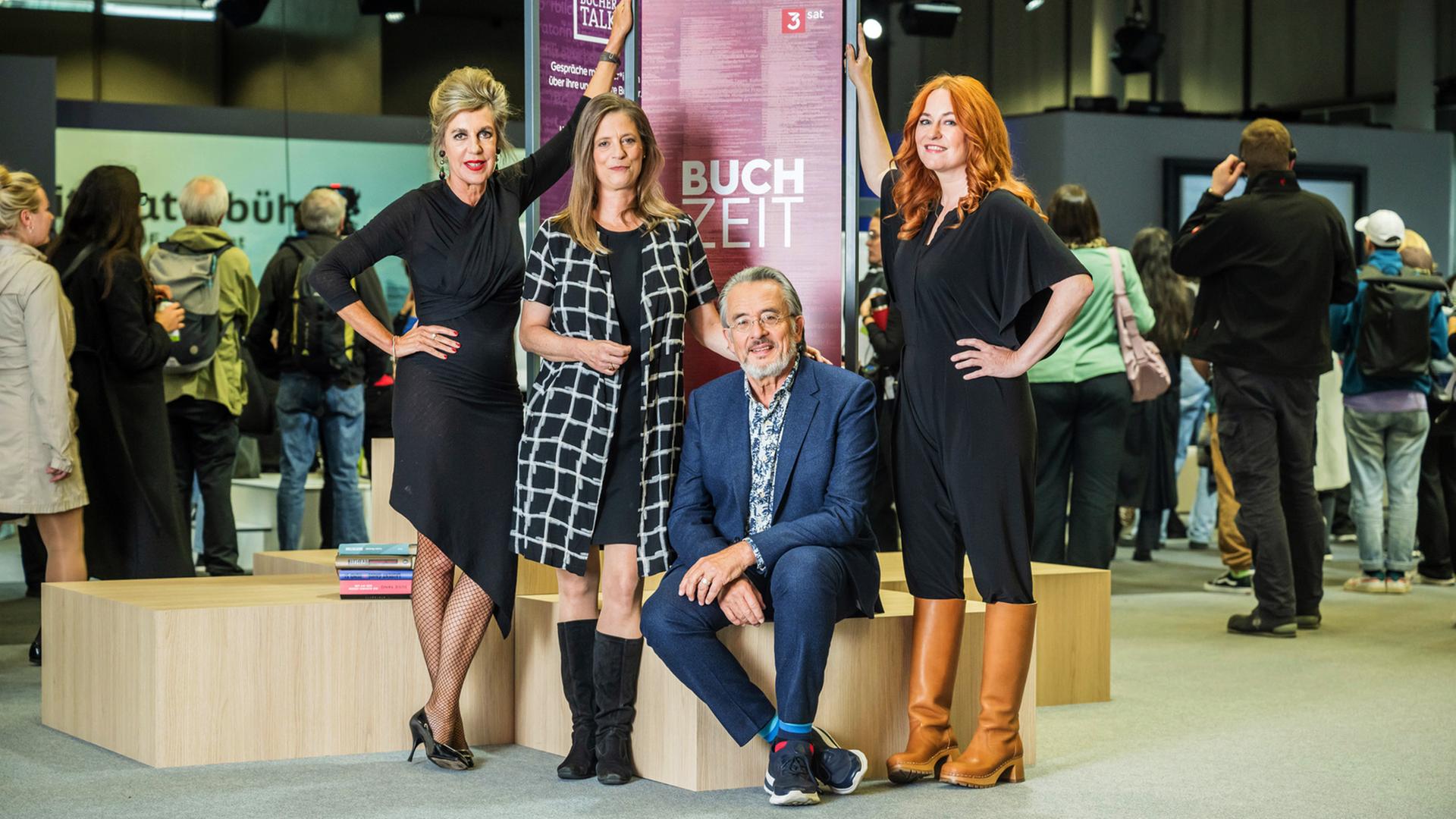 Das Buchzeitteam Barbara Vinken, Sandra Kegel, Gert Scobel und Katrin Schumacher vor einem Buchzeit-Aufsteller auf der Frankfurter Buchmesse 2023.
