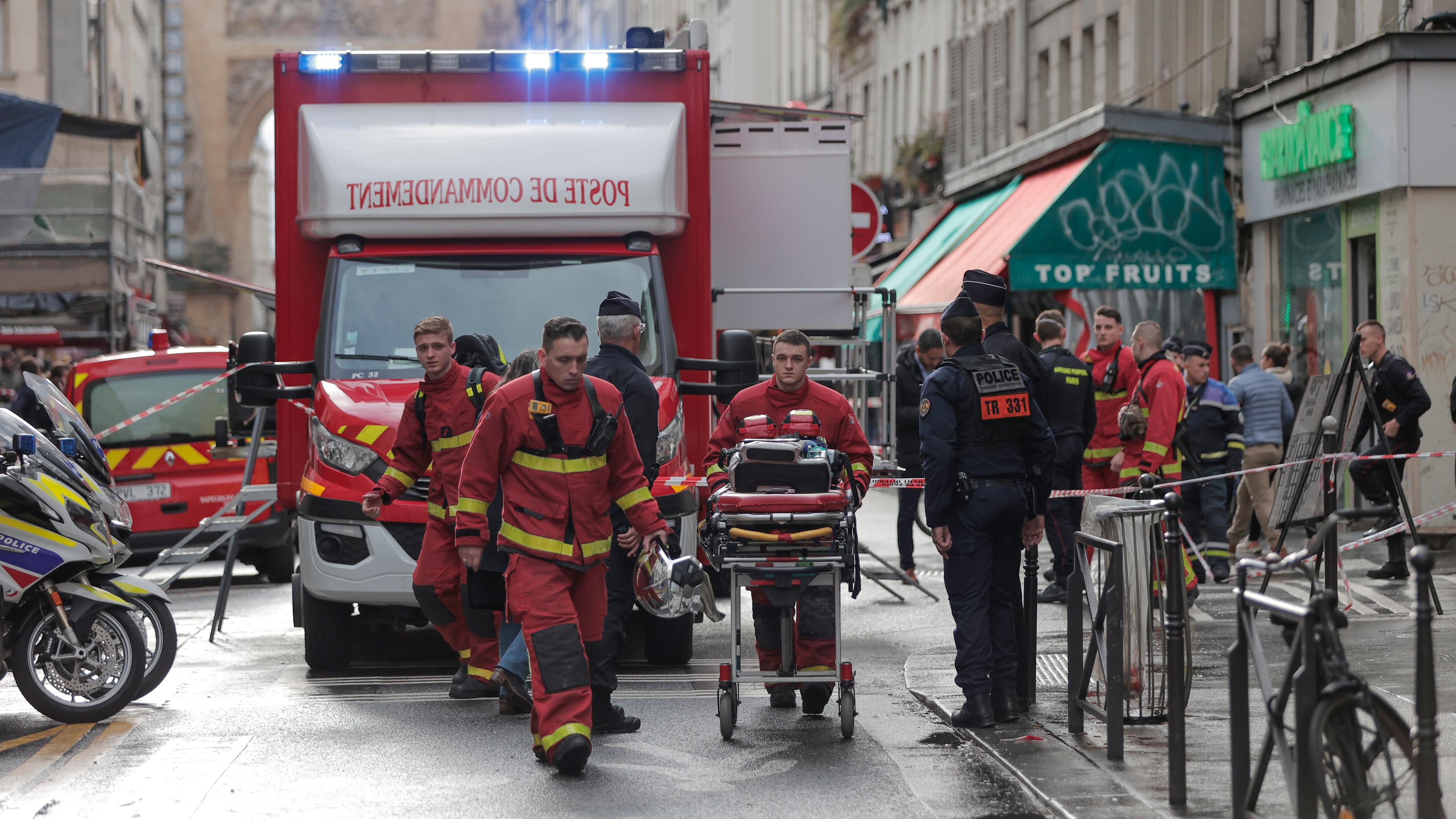 Feuerwehrsanitäter arbeiten am Tatort, nachdem im zehnten Pariser Arrondissement Schüsse abgefeuert wurden.