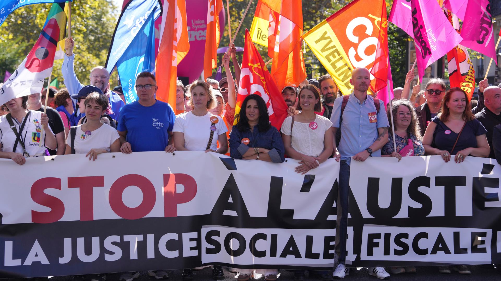 Protestbewegung. Sie halten große Schilder in der Hand. Hinter ihnen wehen Flaggen