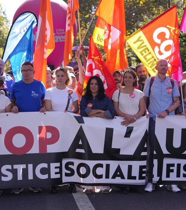 Protestbewegung. Sie halten große Schilder in der Hand. Hinter ihnen wehen Flaggen
