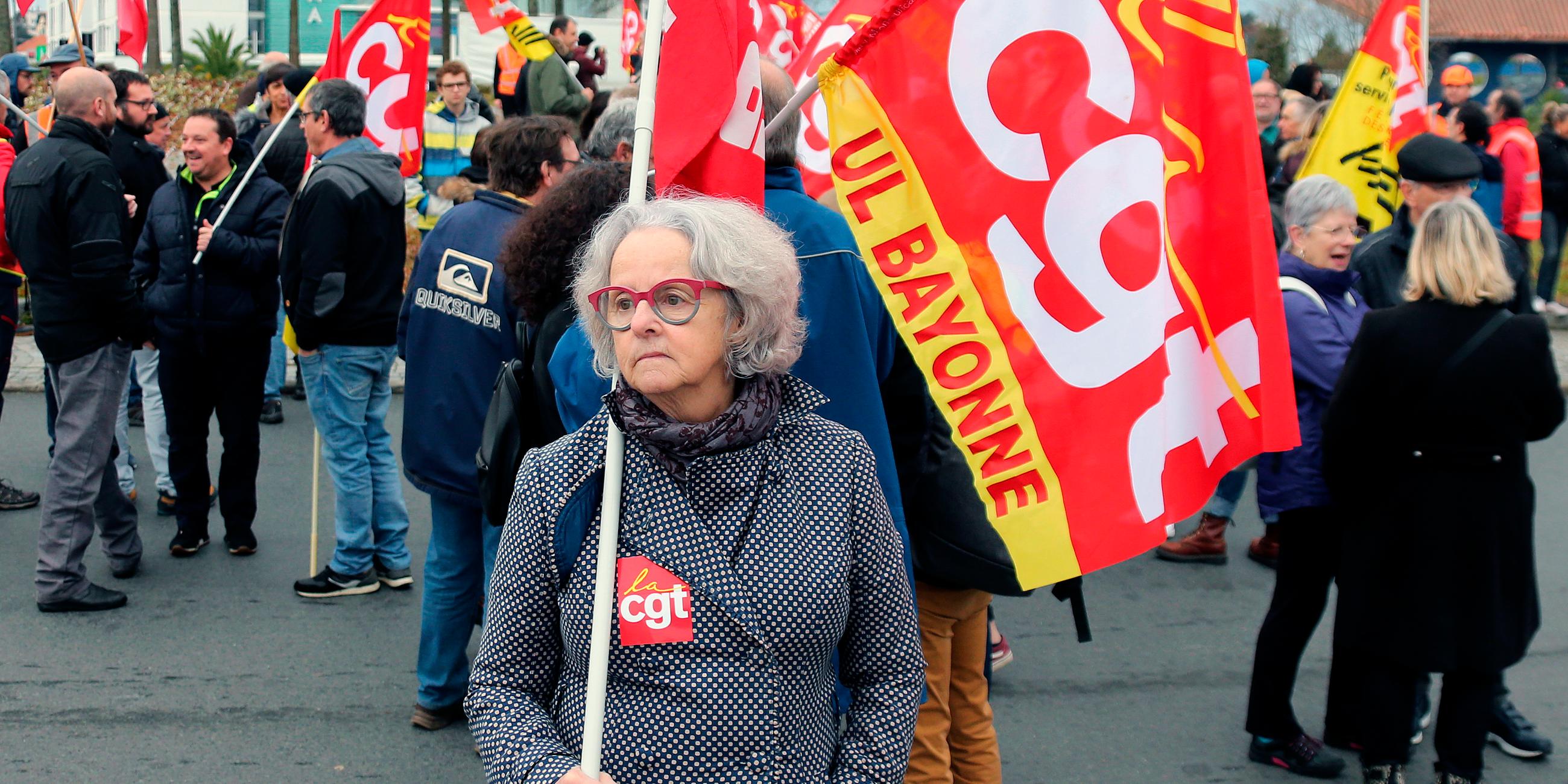Frankreich, Anglet: Eine Demonstrantin trägt während eines Protestes eine Flagge des Gewerkschaftsbundes cgt. Archivbild