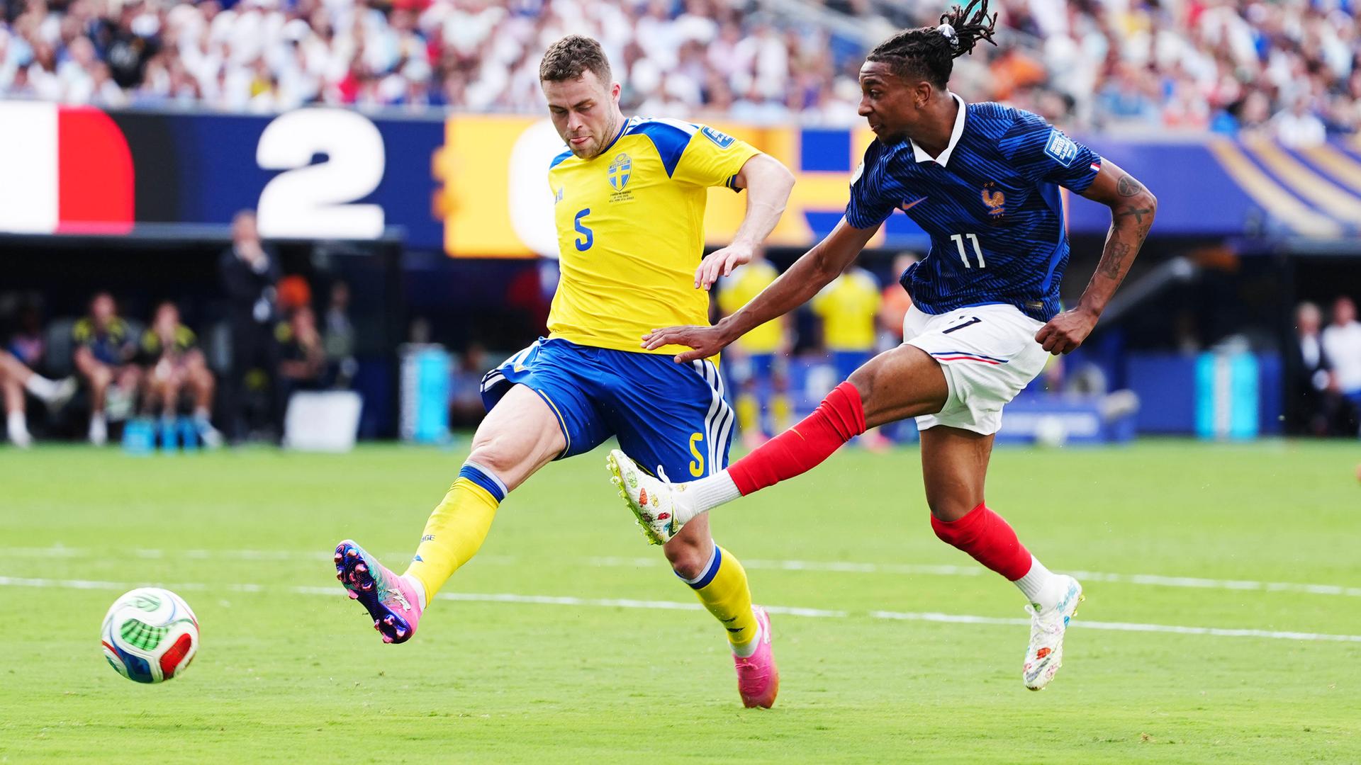Michael Olise (Frankreich) und Gabriel Gudmundsson (Schweden) kämpfen. 