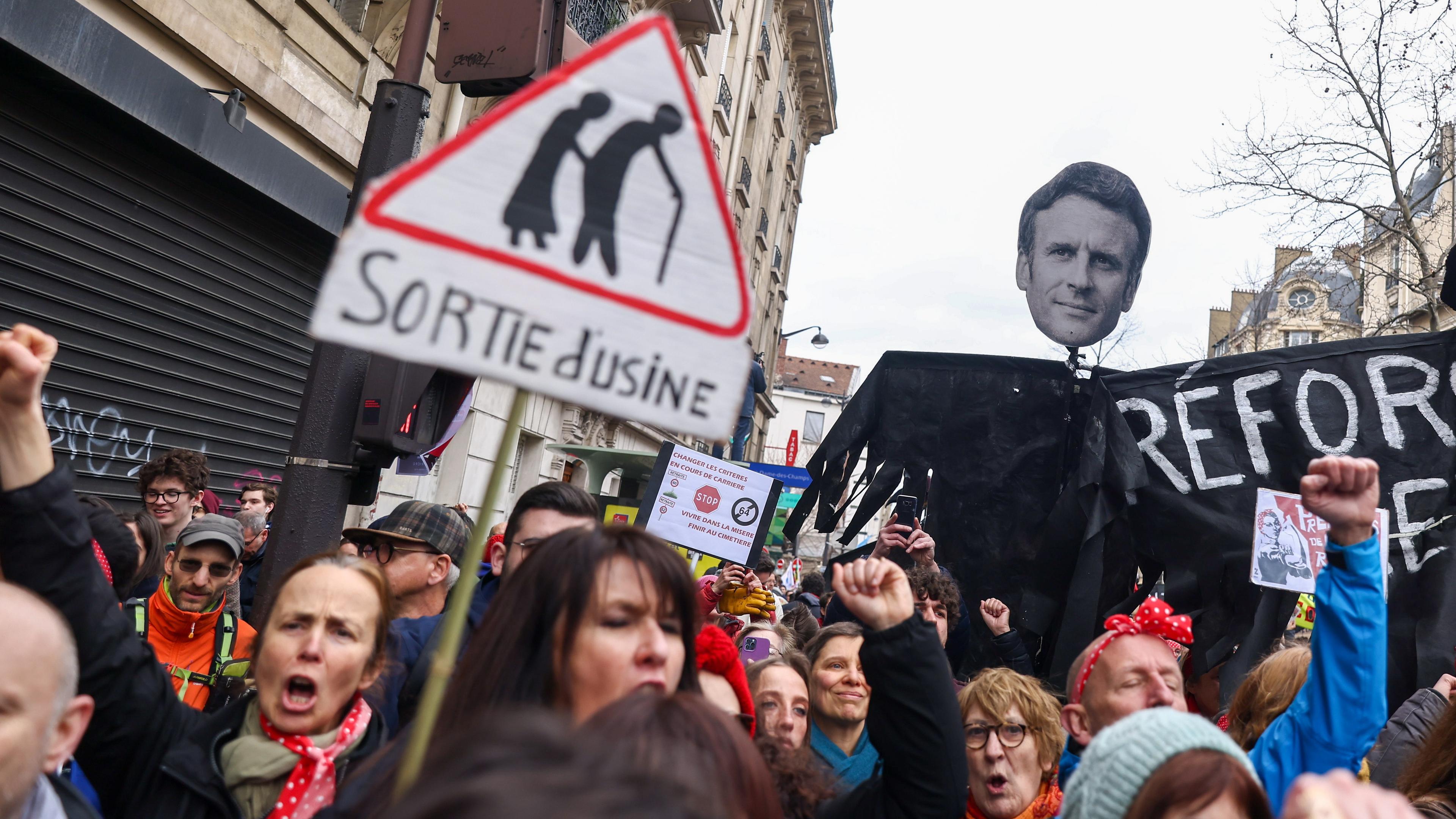 Menschen protestieren mit Plakaten in Frankreich gegen die geplante Rentenreform