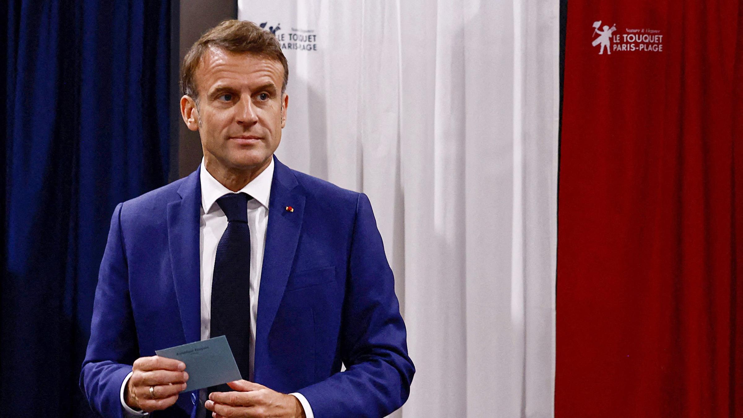 Frankreichs Präsident Emmanuel Macron verlässt die Wahlkabine, bevor er am 30. Juni 2024 in einem Wahllokal in Le Touquet, Nordfrankreich, seine Stimme in der ersten Runde der Parlamentswahlen abgibt.