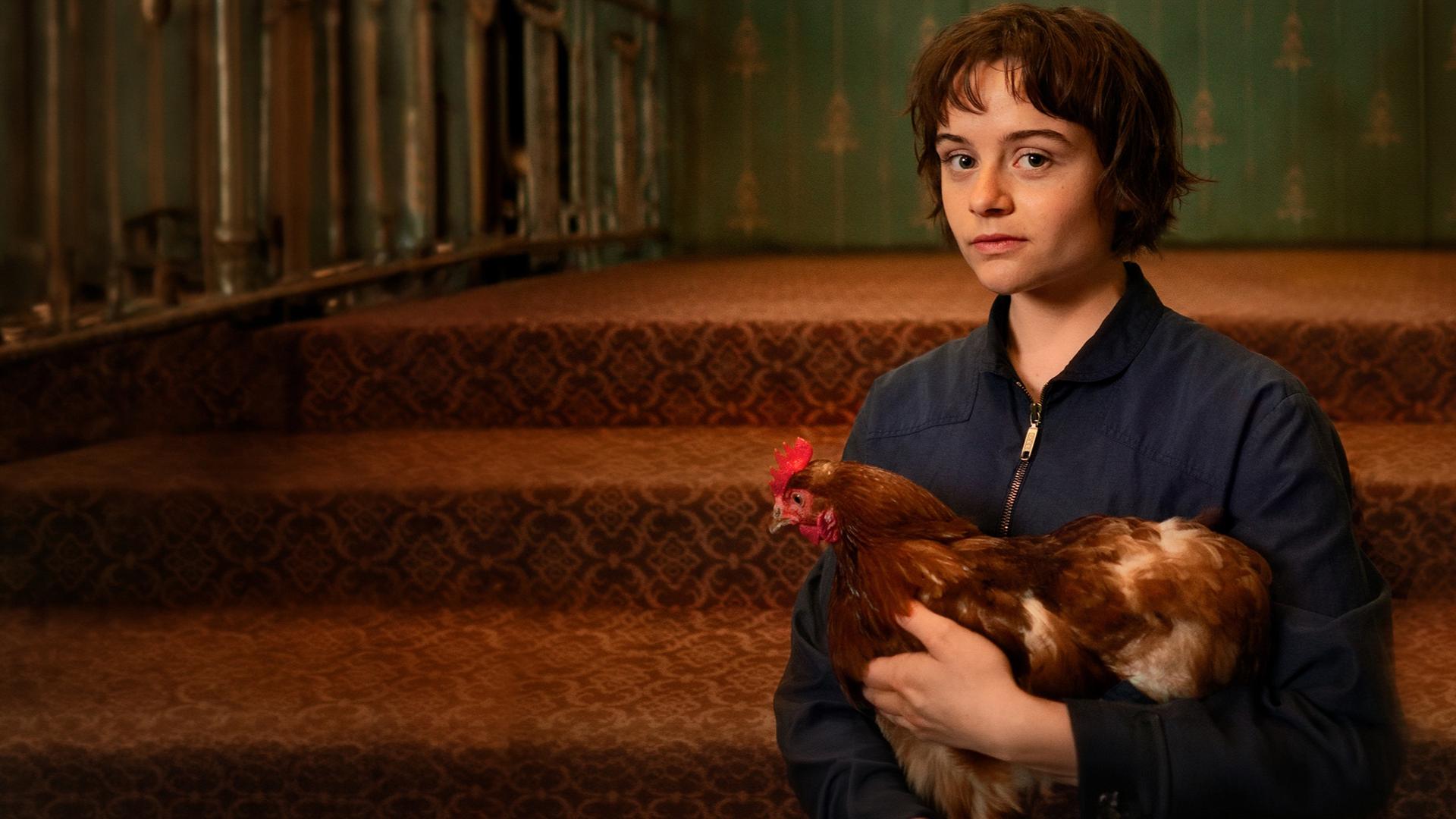 Franky (Lena Urzendowsky) hält ihr Huhn im Arm.