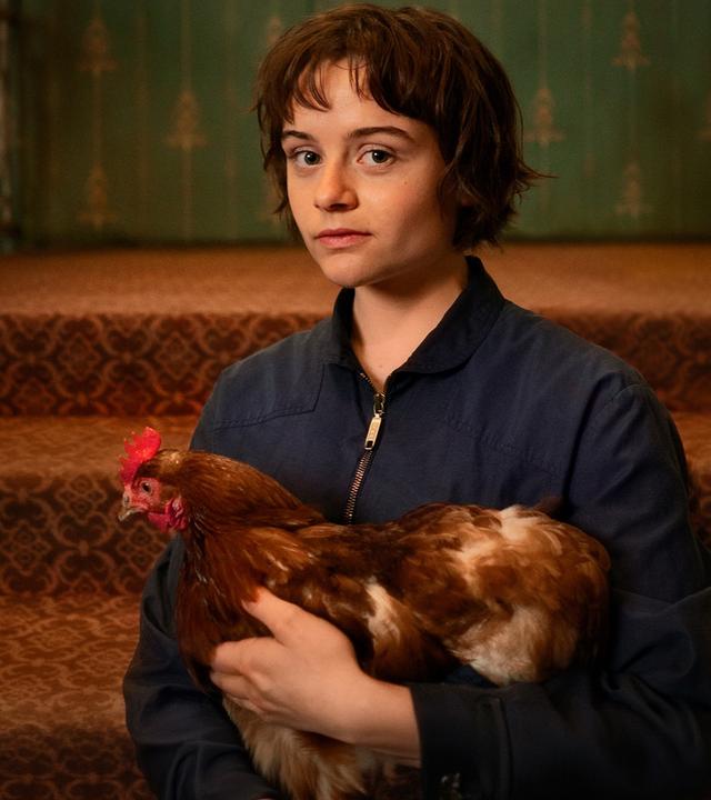 Franky (Lena Urzendowsky) hält ihr Huhn im Arm.