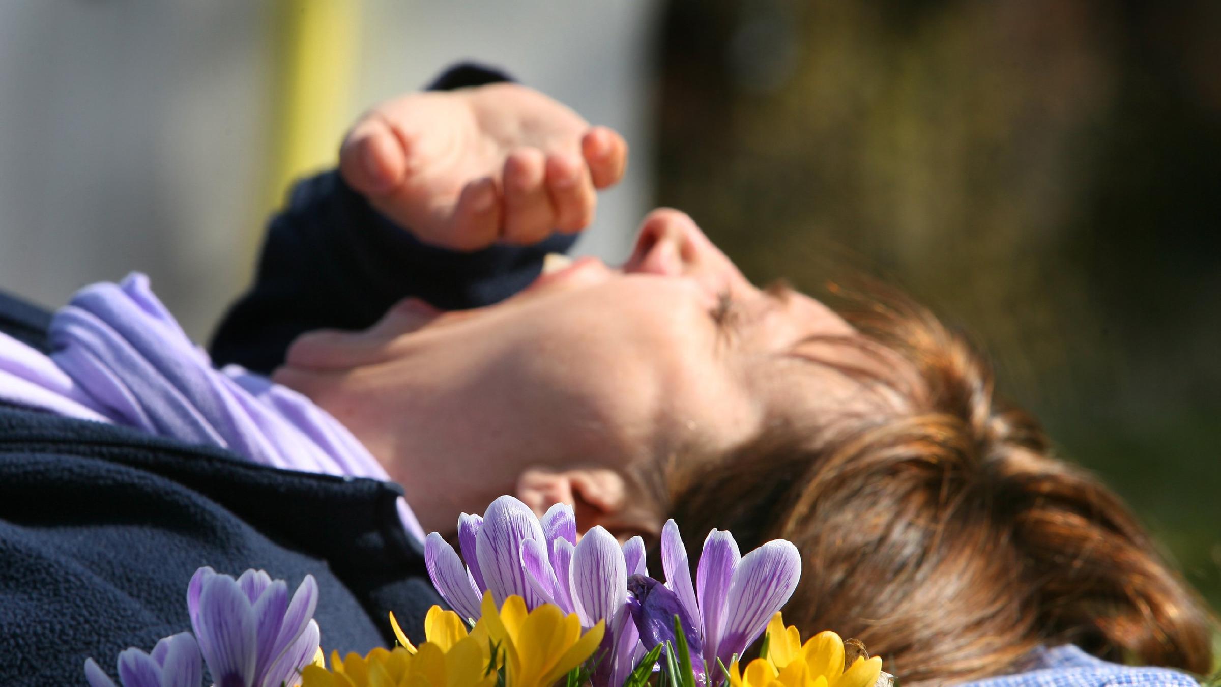 Frau gähnt auf Blumenwiese