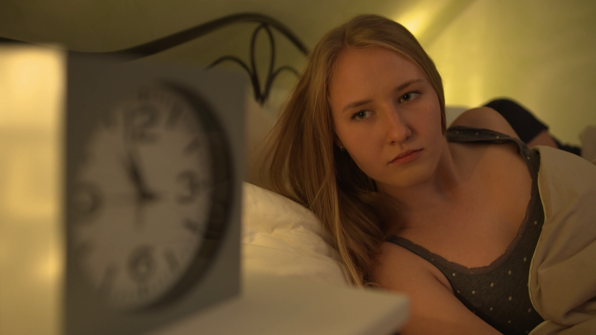 Frau schaut auf Wecker