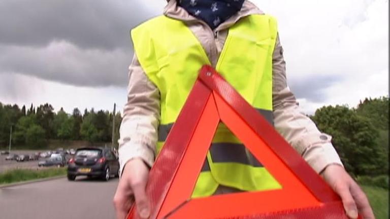 Frau stellt Warndreieck auf