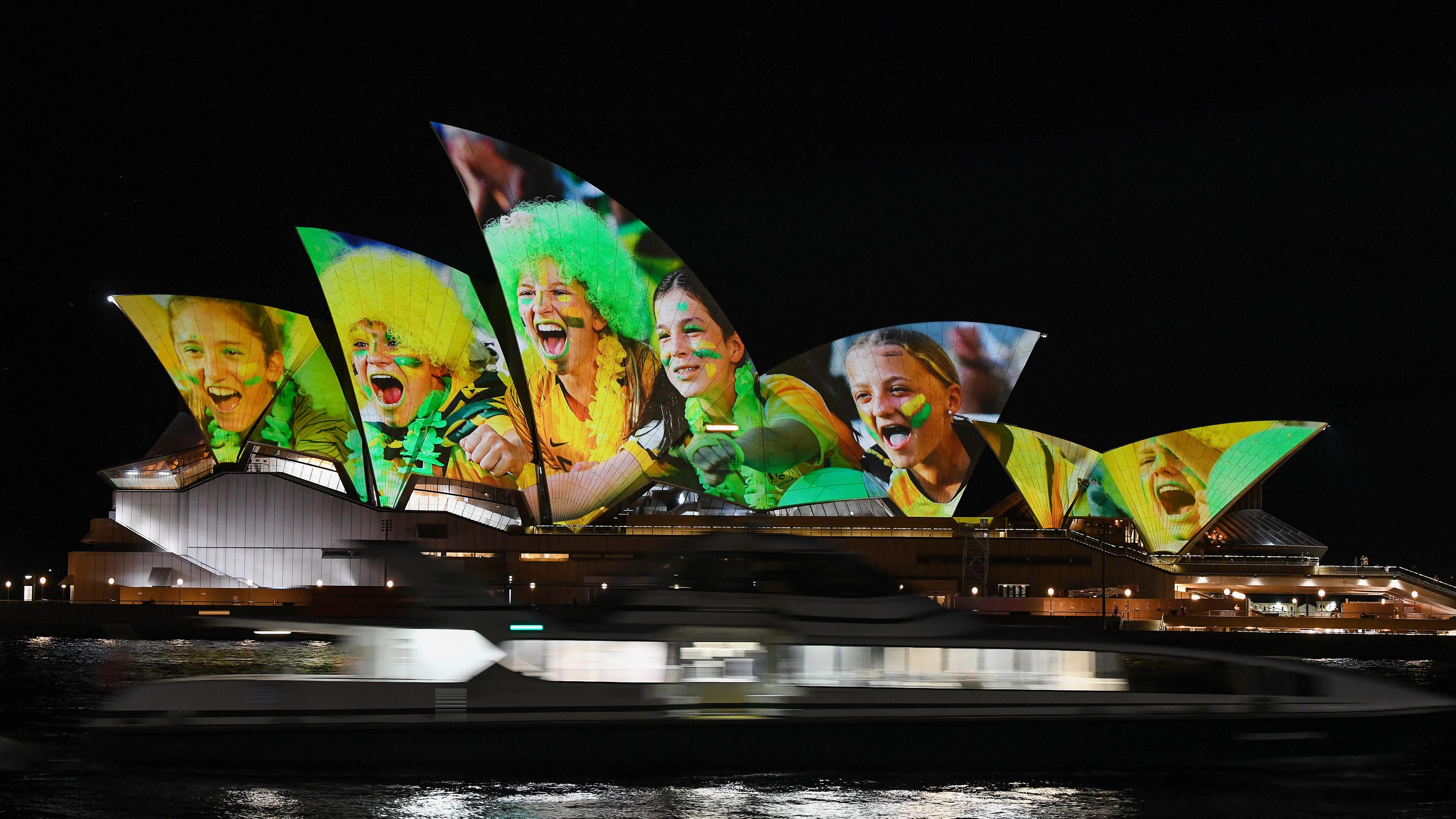 Das Opernhaus ist mit leuchtenden bunten Fotos von Fußball-Fans angestrahl