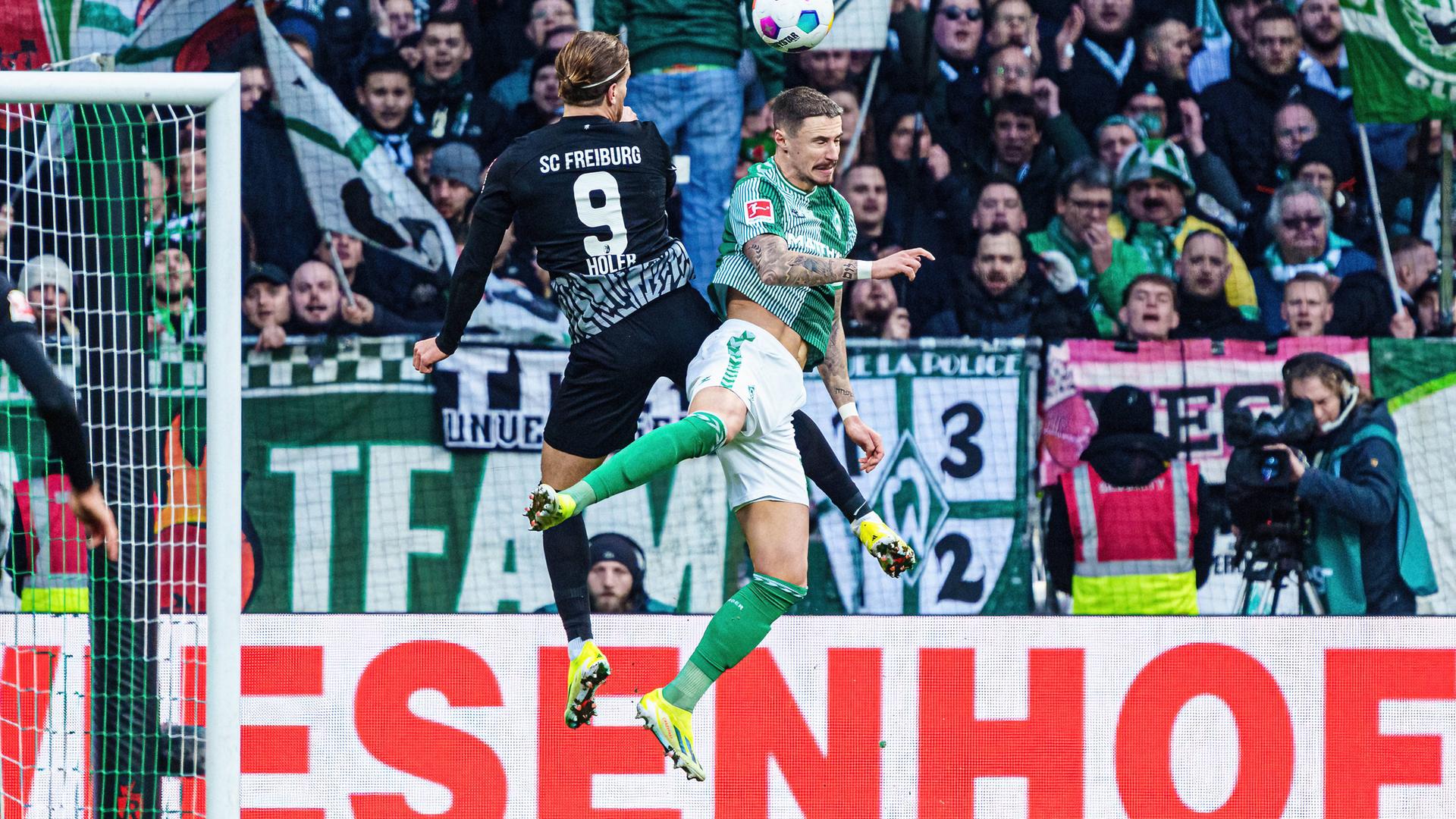 Kopfballduell zwischen Lucas Hoeler (SC Freiburg) und Marco Friedl (SV Werder Bremen).