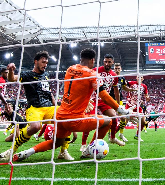 Dortmunds Mats Hummels schießt das Tor zum 2:3 gegen Freiburgs Torwart Noah Atubolu am 16.09.2023.