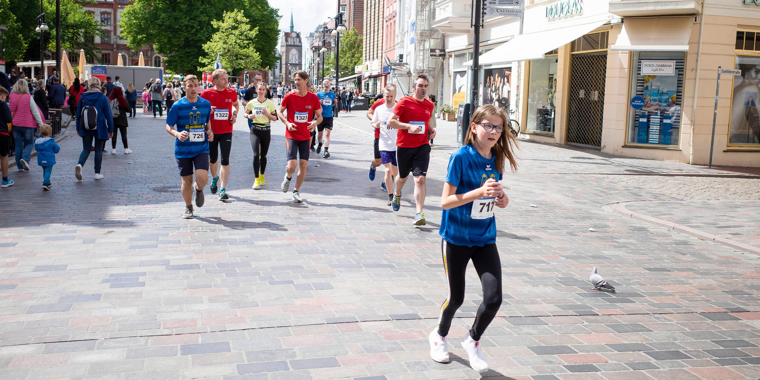 Freizeitsportler nehmen am Rostocker Citylauf teil und laufen durch die Innenstadt.