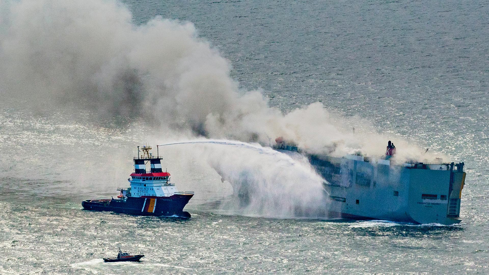 Zu sehen ist ein Boot, das versucht das Frachtschiff zu löschen. 