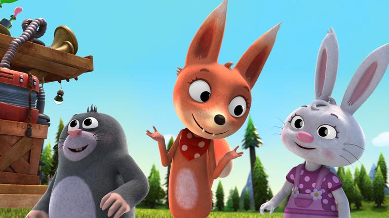 Maulwurf Bodo, Frieda Fuchs und Hase Lotti stehen nebeneinander, Frieda hebt wissend die Arme.