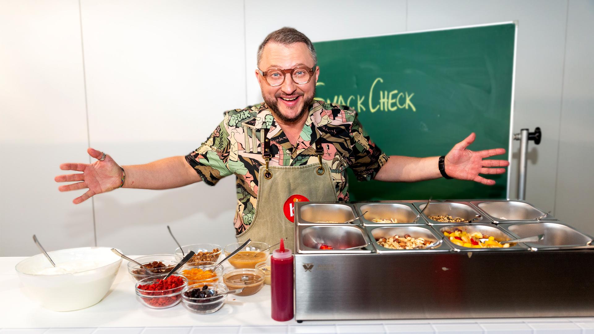 Besseresser Kids: Sebastian Lege steht mit ausgebreiteten Armen in der Schulküche. 