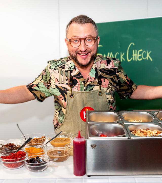 Besseresser Kids: Sebastian Lege steht mit ausgebreiteten Armen in der Schulküche. 