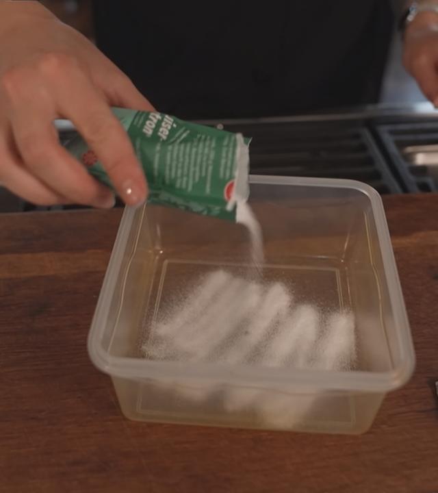 Frischhaltedosen richtig reinigen: In eine Box wird Natronpulver gefüllt.