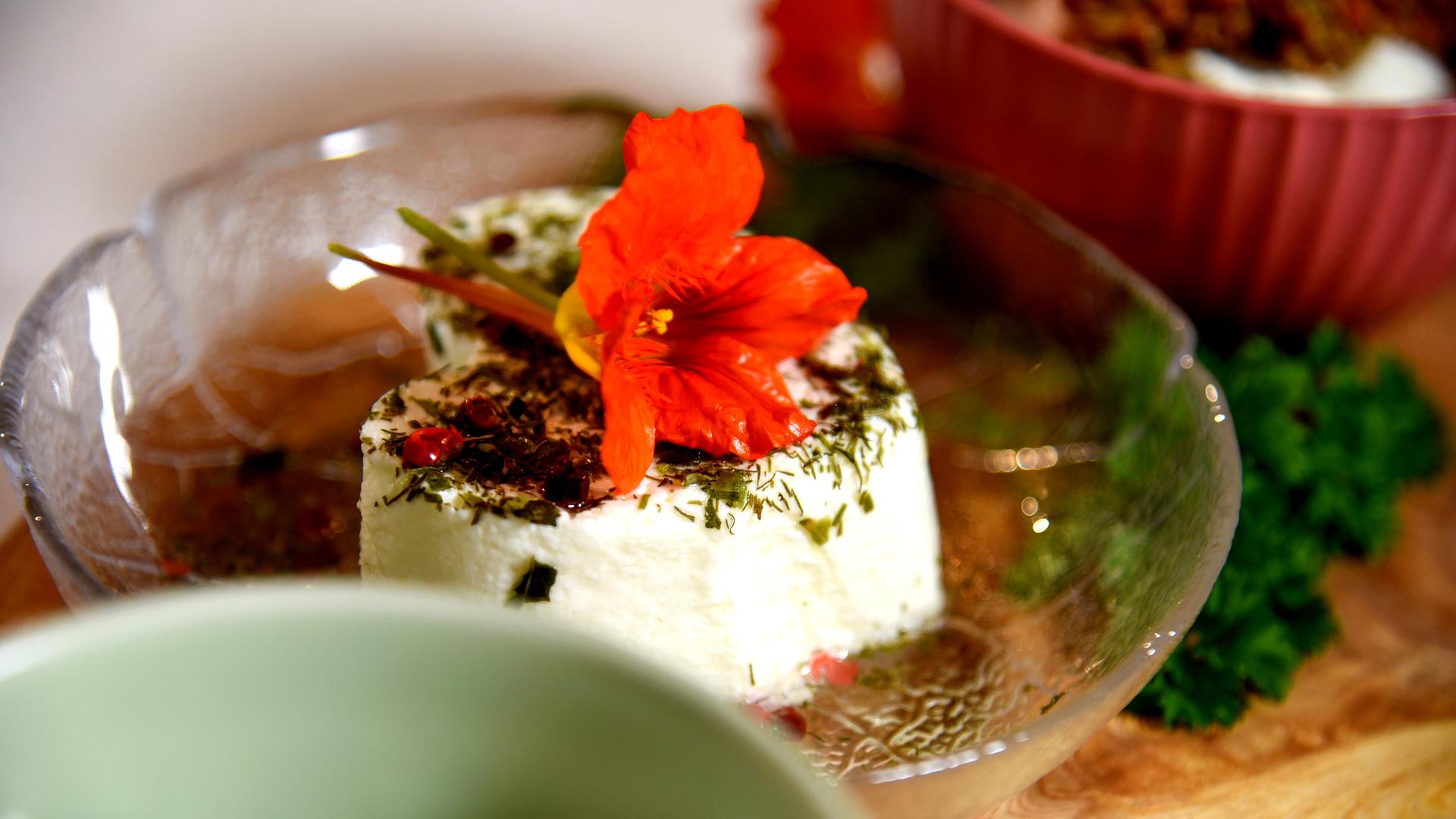 Frischkäsescheibe mit Kabuzinerkresseblüte