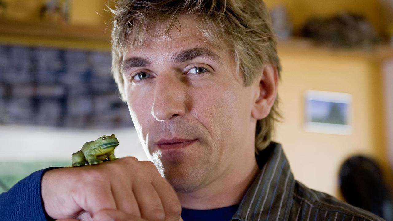 Ein Frosch sitzt auf einem grünen Blatt.