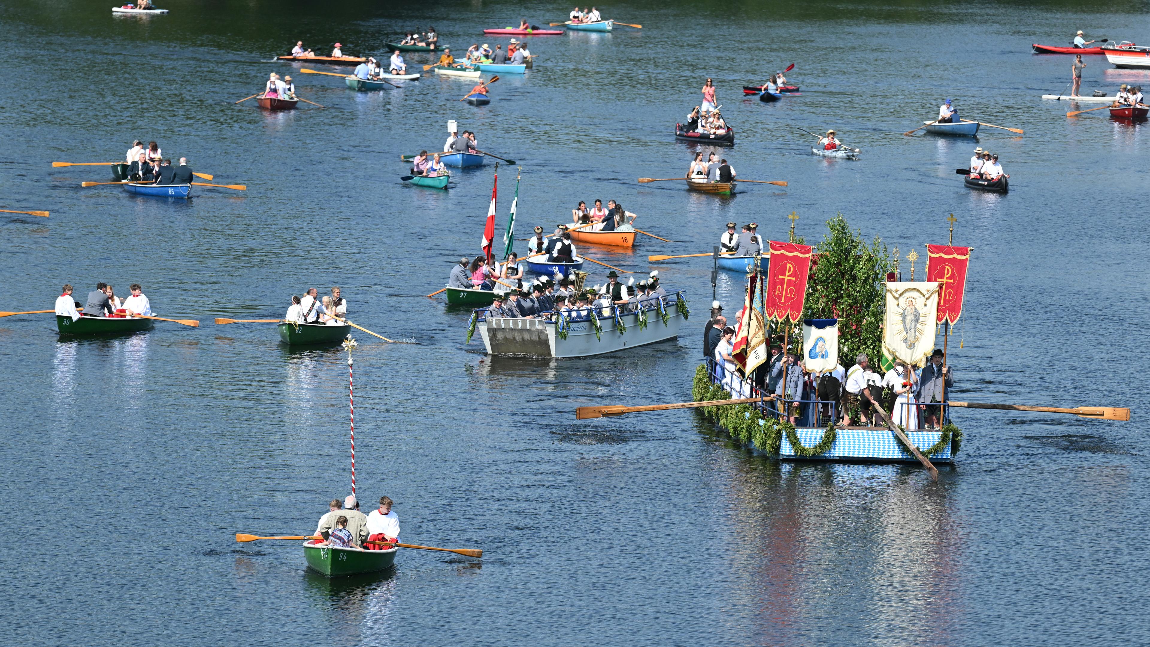 Bayern, Seehausen: Gläubige sitzen bei der Seeprozession auf dem Staffelsee in Booten und verfolgen die Fronleichnamsprozession.