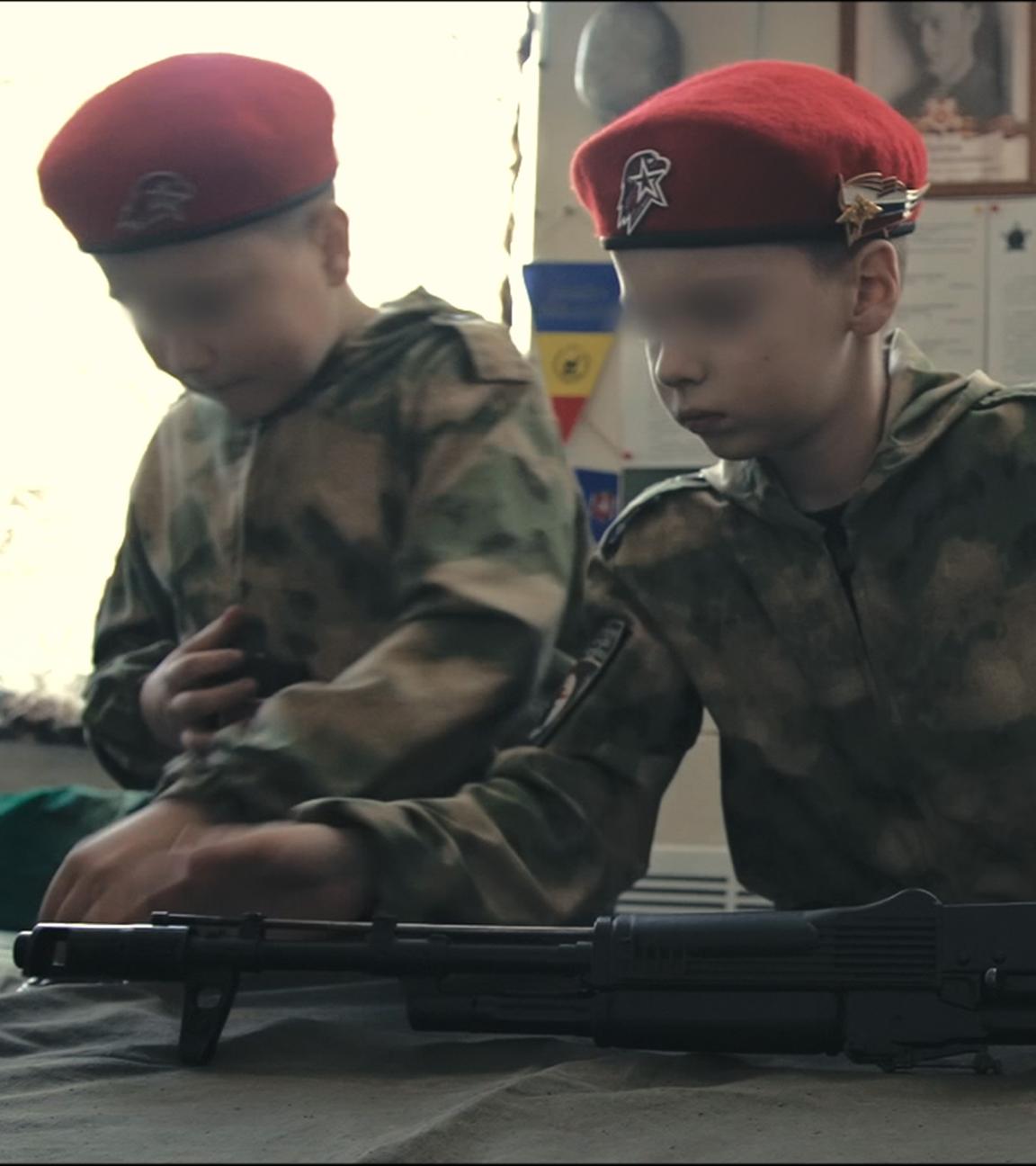 Montage: Kinder werden an Waffen ausgebildet