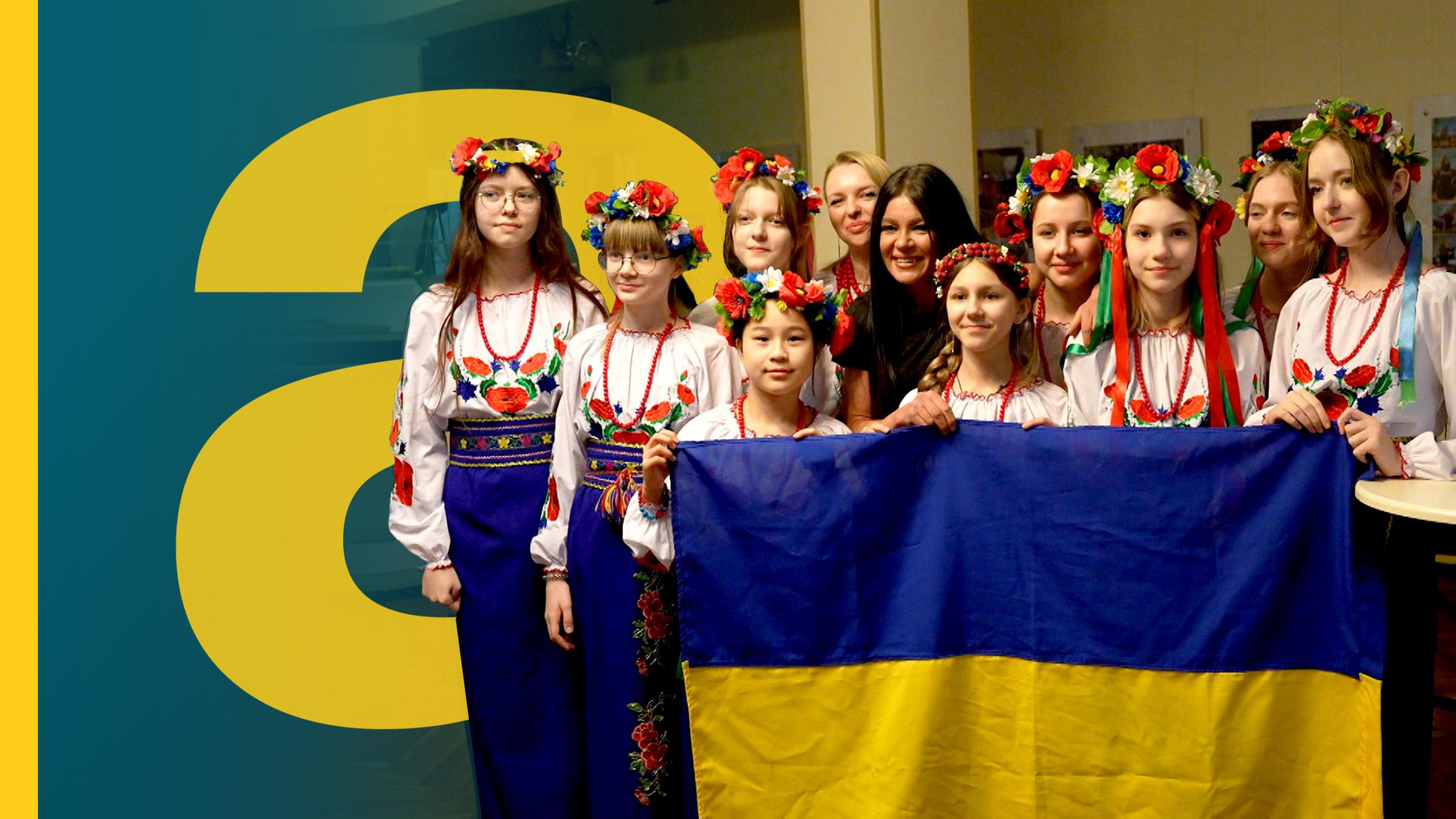 Ukrainische Mädchen in Trachten halten die unkrainische Flagge