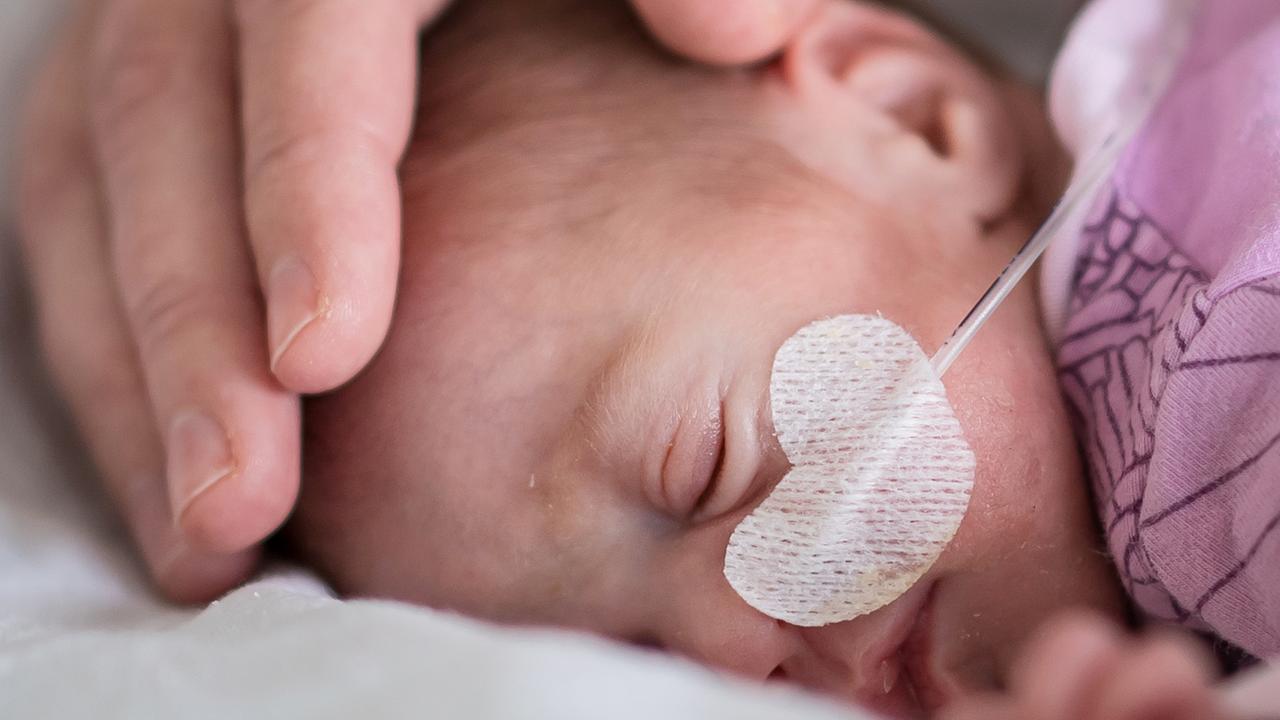 Ein Frühchen liegt im Krankenhaus in einem Bett.