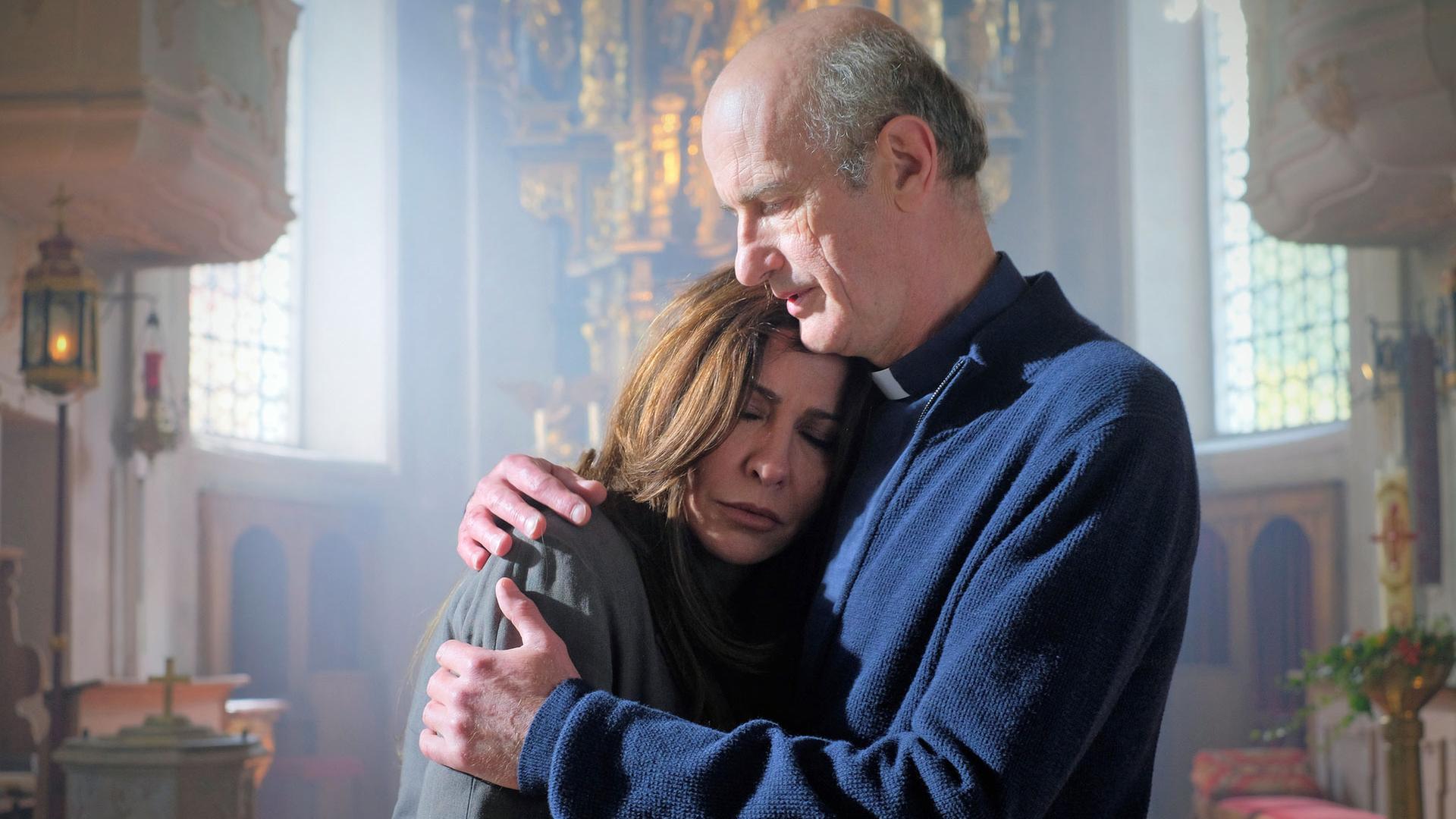 "Frühling - Am Ende des Sommers": Pfarrer Sonnleitner (Johannes Herrschmann) hält in der Frühlinger Kirche Katja Baumann (Simone Thomalla) tröstend im Arm. Sie hat die Augen geschlossen.