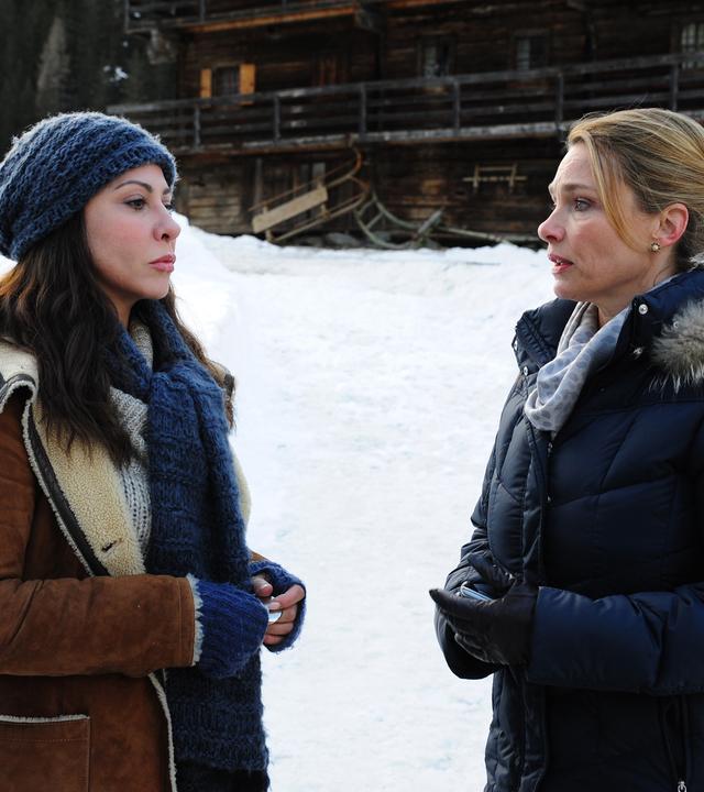  Katja Baumann (Simone Thomalla) und Elke Liebherr (Aglaia Szyszkowitz) stehen sich im Schnee vor einem Holzhaus gegenüber. Beide schauen besorgt.