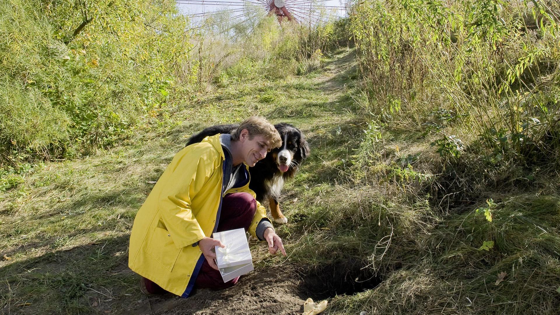 Keks und Fritz stehen an einem Fuchsbau und schauen hinein.