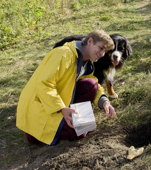 Keks und Fritz stehen an einem Fuchsbau und schauen hinein.