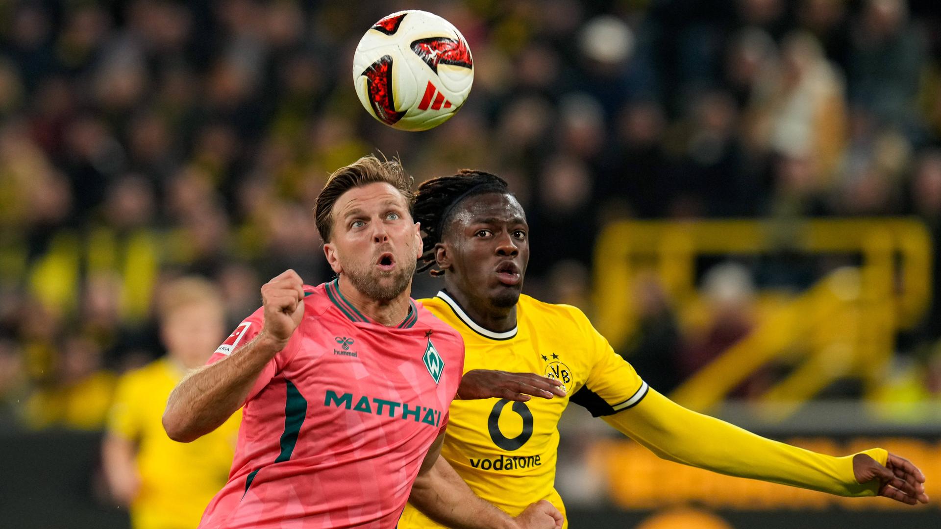 Werder Bremens Stürmer Niclas Füllkrug versucht sich im Zweikampf gegen seinen Dortmunder Kontrahenten Joane Gadou durchzusetzen