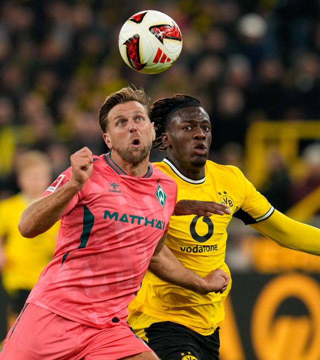 Werder Bremens Stürmer Niclas Füllkrug versucht sich im Zweikampf gegen seinen Dortmunder Kontrahenten Joane Gadou durchzusetzen