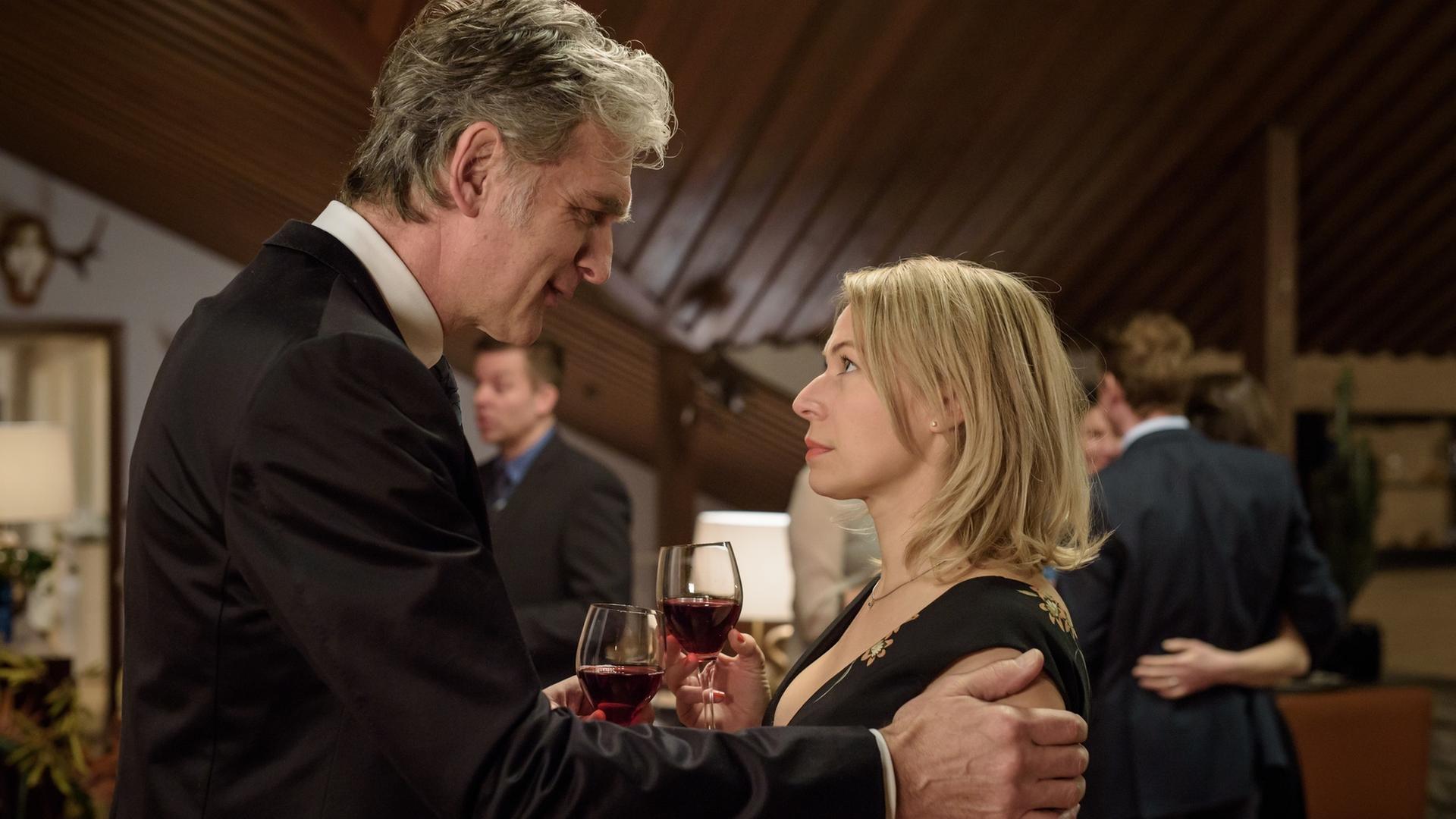 "Der Kommissar und das Meer - F&uuml;r immer Dein": Robert Anders (Walter Sittler) und Emma Winarve (Frida Hallgren) genie&szlig;en einen gemeinsamen Abend bei Freunden und sto&szlig;en mit Rotwein an.